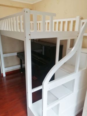 Physical photo: Clean white bed frame + stair cabinet (ladder on the right)