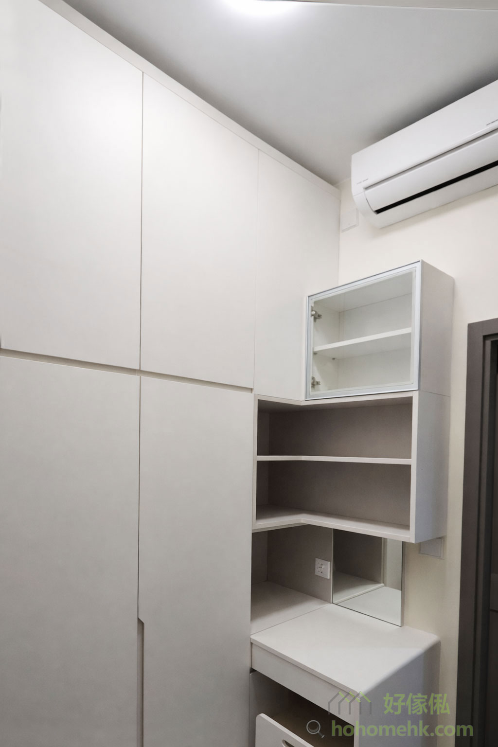 衣帽間以淺灰色櫃體為主，搭配玻璃門設計，提升通透感之餘，也方便展示香水及飾物等精品。內部布局合理，將掛衣區與儲物格巧妙結合，讓空間利用率達到最高，滿足日常收納需求之餘，還保有高質感的視覺效果。