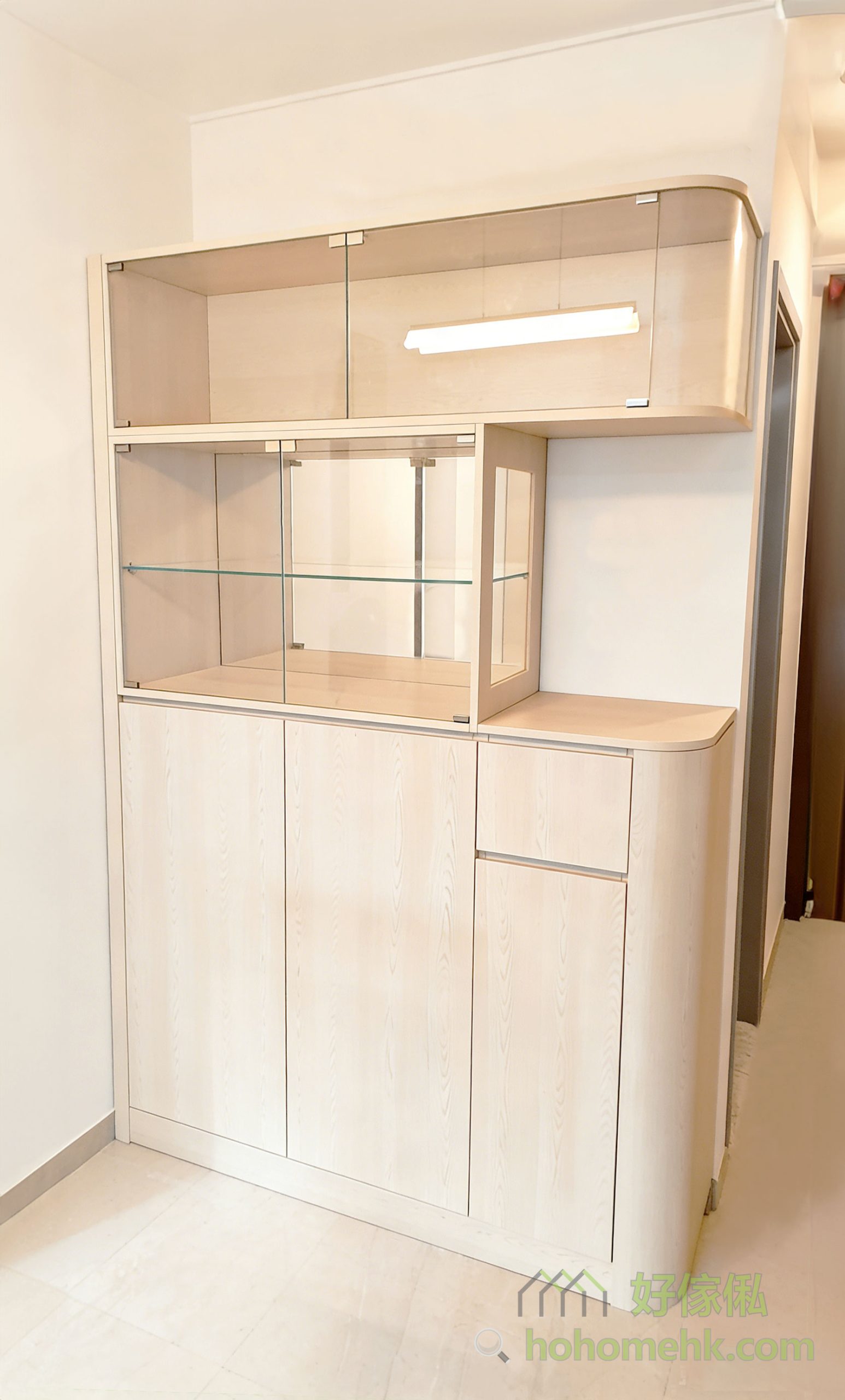 玻璃飾櫃的弧形玻璃設計，配合圓邊木櫃身，帶來柔和且流暢的視覺效果。這樣的設計不僅提升整體美感，更避免了傳統櫃體的尖銳邊角，適合家有小朋友或追求安全的家庭。