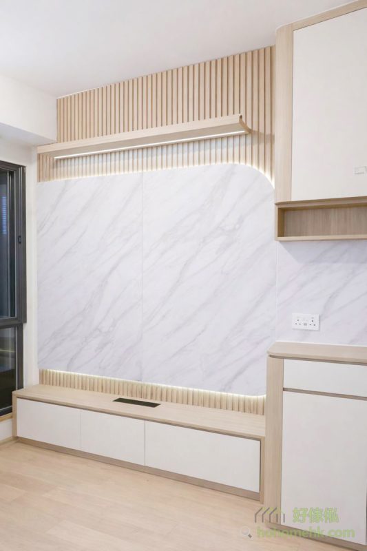 今次案例的電視櫃背景牆採用雙層設計，底層為淺木色條子牆，面層則以白色雲石紋板作點綴，為空間增添視覺層次感。內部特別設計了隱藏電線的功能，既提升整體美觀度，又方便日後整理，真正做到功能與外觀兼備。
