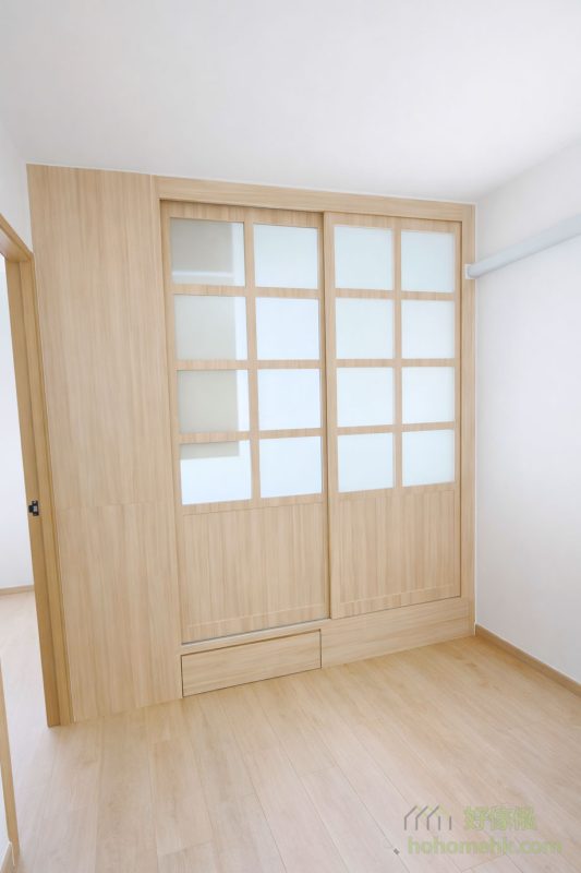 我們為客戶設計了一款日式趟門，上半部分採用木框磨砂玻璃，下半部分則為木板，令自然光可以穿透，為客廳帶來明亮感，同時保留房間的私密性，達到實用與美觀的平衡。