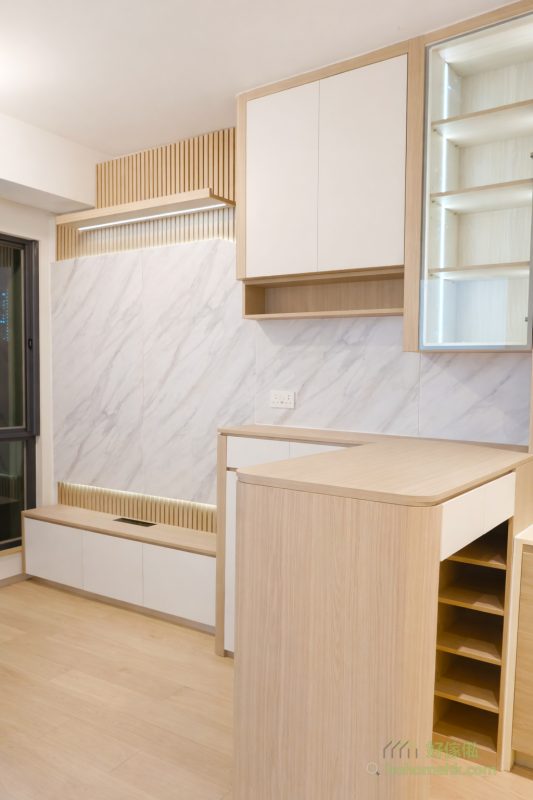 今次案例的電視櫃背景牆採用雙層設計，底層為淺木色條子牆，面層則以白色雲石紋板作點綴，為空間增添視覺層次感。內部特別設計了隱藏電線的功能，既提升整體美觀度，又方便日後整理，真正做到功能與外觀兼備。