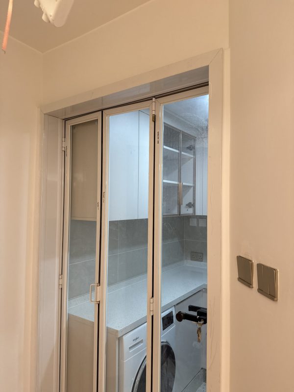 廚房門訂造了3摺門，清玻配白框，與淺色廚櫃非常match！摺門可以預留較大的出入通道，日後要更換洗衣機及雪櫃都比較方便。