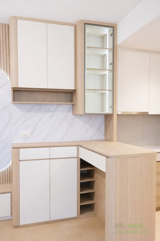 開放式廚房越來越普及，客廳與飯廳之間加入了一組C字櫃，並搭配一張高枱，既能作為小型吧枱享受輕鬆一刻，又自然地分隔出不同的家居功能區域。這種設計不僅提高空間利用率，還為整體環境注入現代感和實用性。