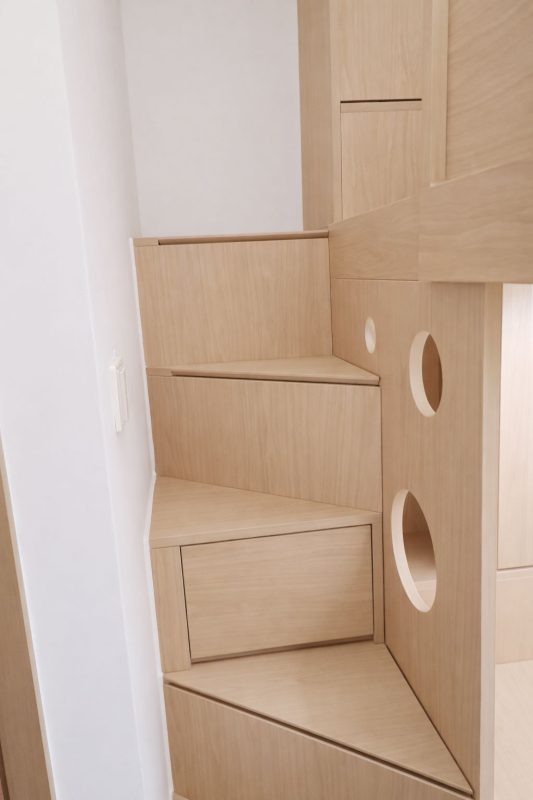 我們的設計不但考慮到儲物功能，還在細節上提升用戶體驗。樓梯櫃提供了額外的儲物空間，還巧妙地成為下床的屏風，增強下床位置的私隱度。每個樓梯都經過精心設計，兼顧實用和美觀，是小空間內不可多得的亮點，因為空間有限，所以每級樓梯做成三角形錯開的排列，用更少的空間就做到容易上落的樓梯櫃。