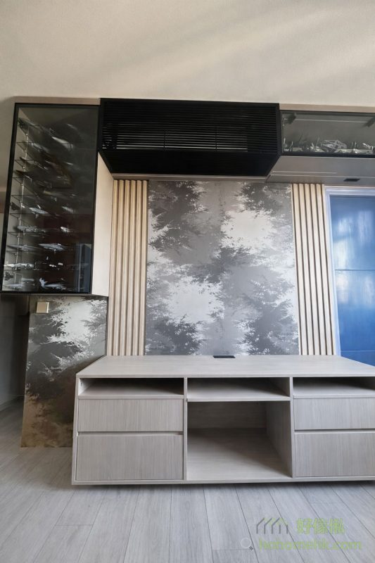 暮色系的電視櫃設計以深色為主，背板運用了「月影」色板，增添了一種神秘優雅的氛圍。這種設計與客戶原有的玻璃飾櫃完美融合，既保留了整體空間的和諧美感，又突出了訂造傢俬的獨特風格，是現代型格家居的理想選擇。