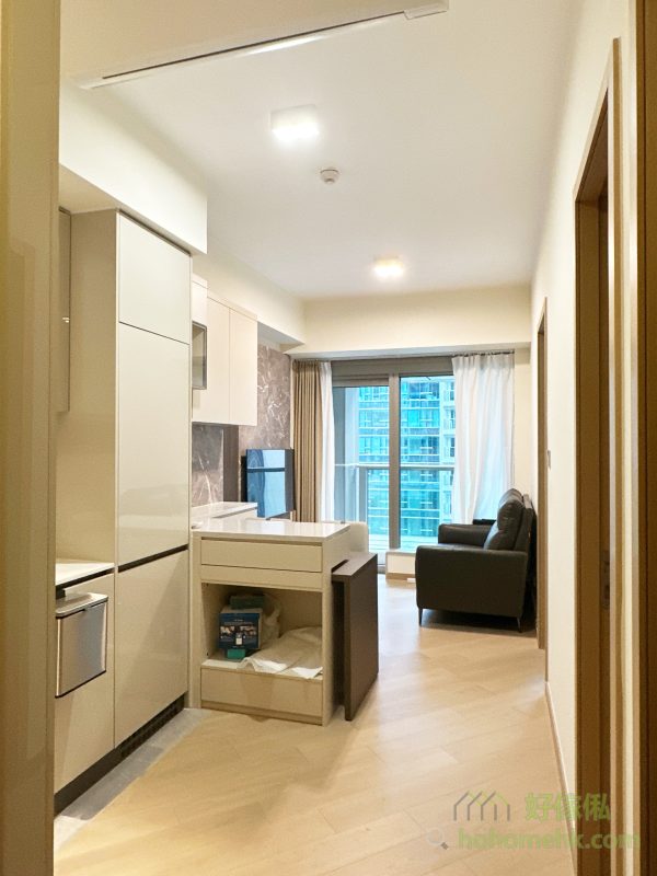 廳櫃與吧枱的設計不僅是廚房與客廳的分隔，更能透過石面枱面的延伸大幅增加廚櫃的工作枱面。特別是錯層的創新設計，讓餐枱藏於吧枱之下，需要時可拉出變成獨立餐枱，節省空間之餘，亦讓中島更具層次感與特色，滿足現代家庭對靈活性的需求。