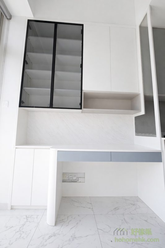 廚櫃旁的書枱設計，既具靈活性，亦照顧到實際工作需要。書枱內建電掣與插蘇位，方便接駁電腦和其他設備；書櫃提供足夠的書籍或文件存放空間，保持桌面整潔。同時，展示與收納兼備，將開放式單位打造成功能齊備的家居辦公空間。
